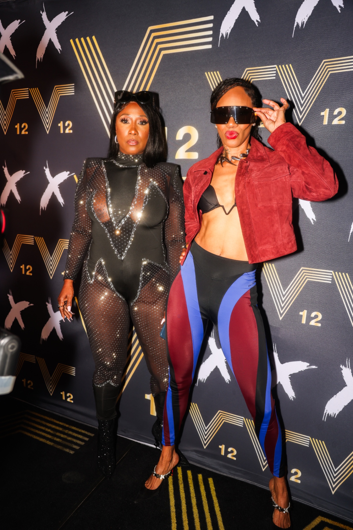 Two guests posing on the gold step-and-repeat