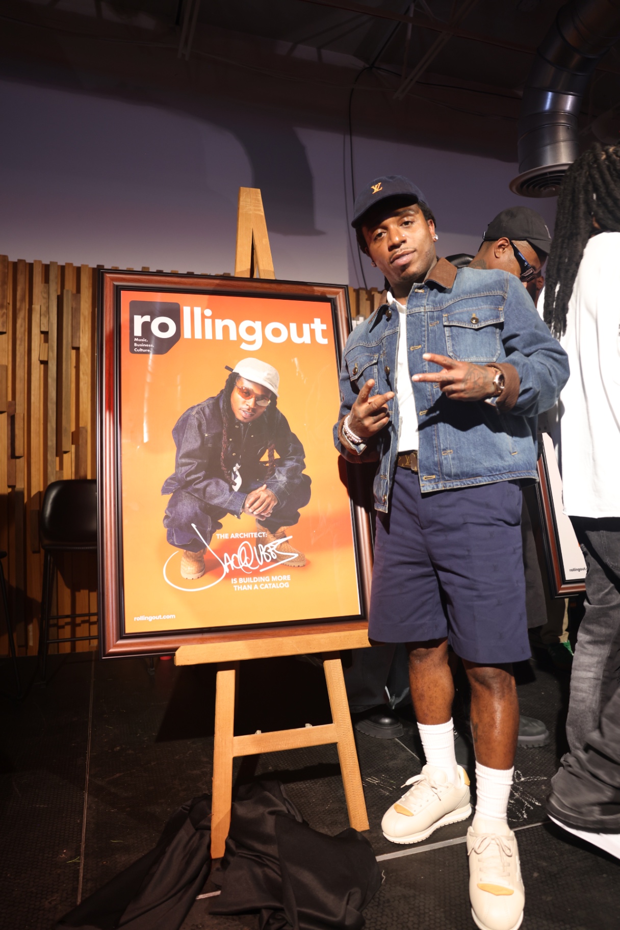 Artist posing with his Rolling Out cover at the release event